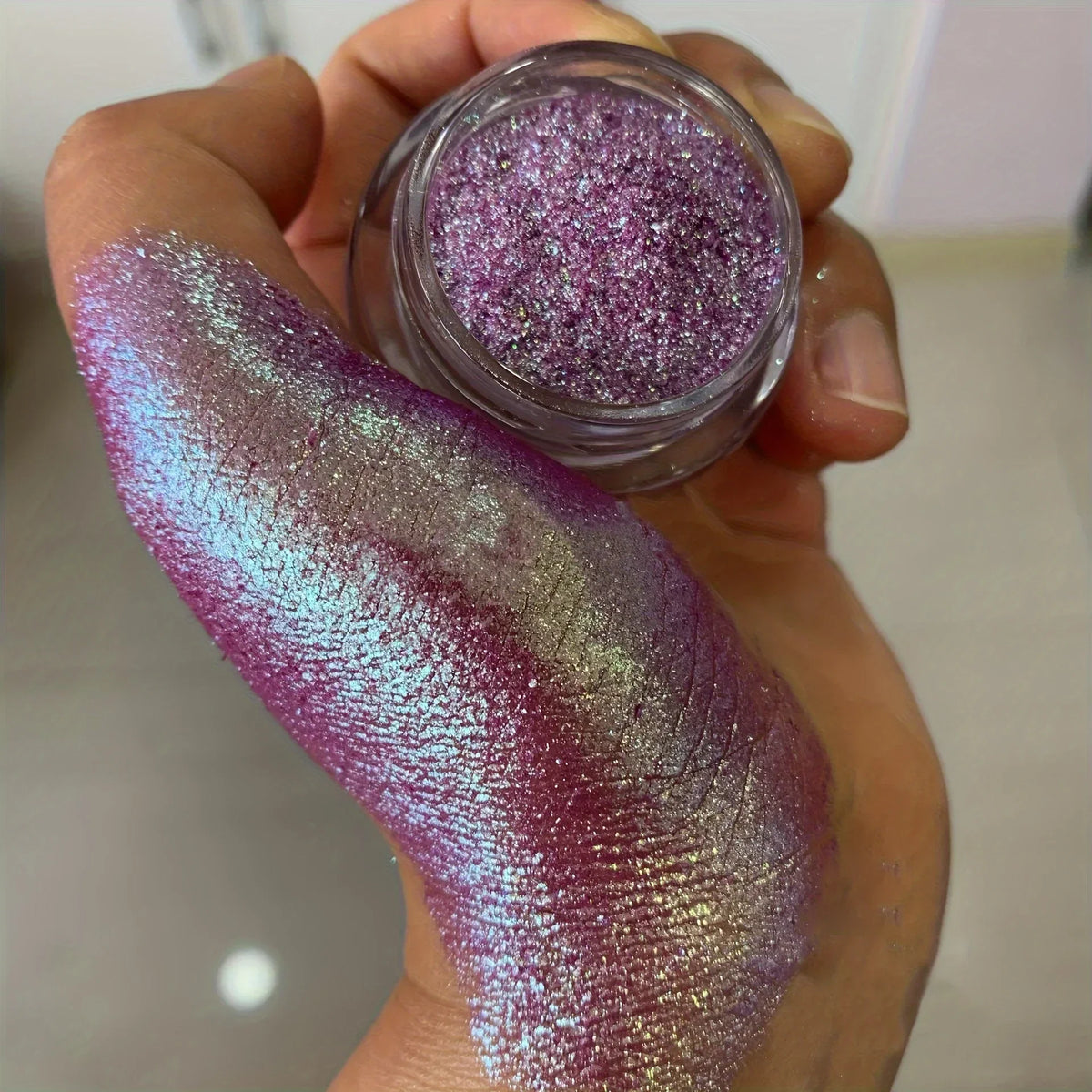 Polvo glitter aurora camaleón vibrante, degradado multicolor, tonos mora, morado, azul y verde, maquillaje corporal deslumbrante
