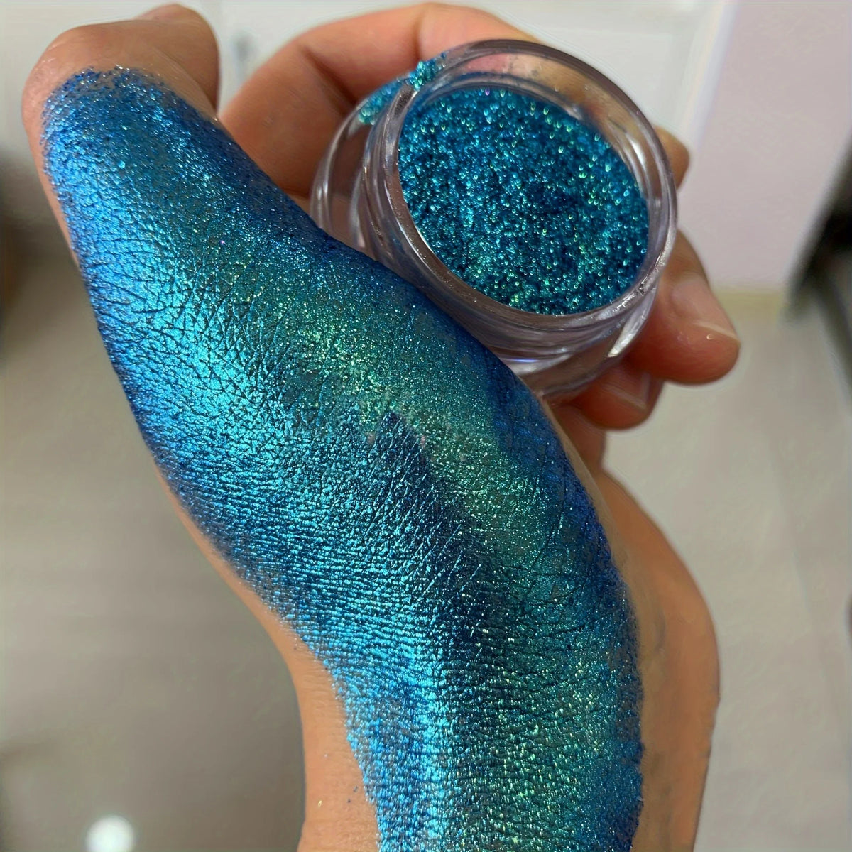 Polvo glitter aurora camaleón vibrante, degradado multicolor, tonos mora, morado, azul y verde, maquillaje corporal deslumbrante