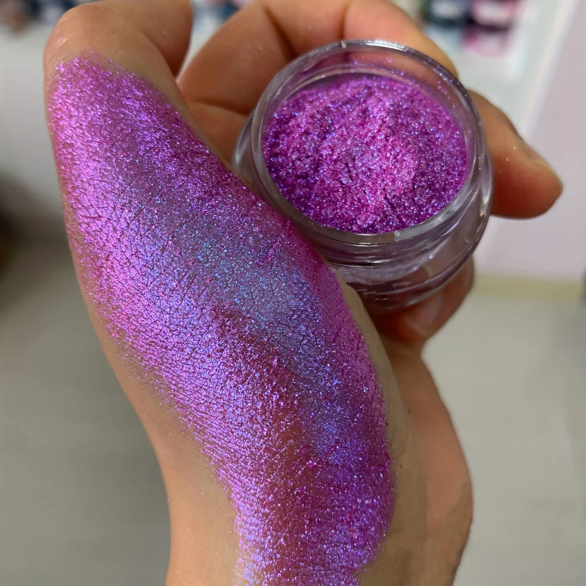 Polvo glitter aurora camaleón vibrante, degradado multicolor, tonos mora, morado, azul y verde, maquillaje corporal deslumbrante