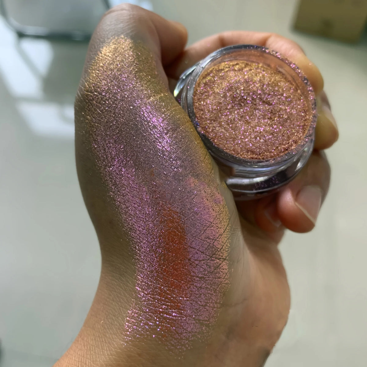 Polvo glitter aurora camaleón vibrante, degradado multicolor, tonos mora, morado, azul y verde, maquillaje corporal deslumbrante