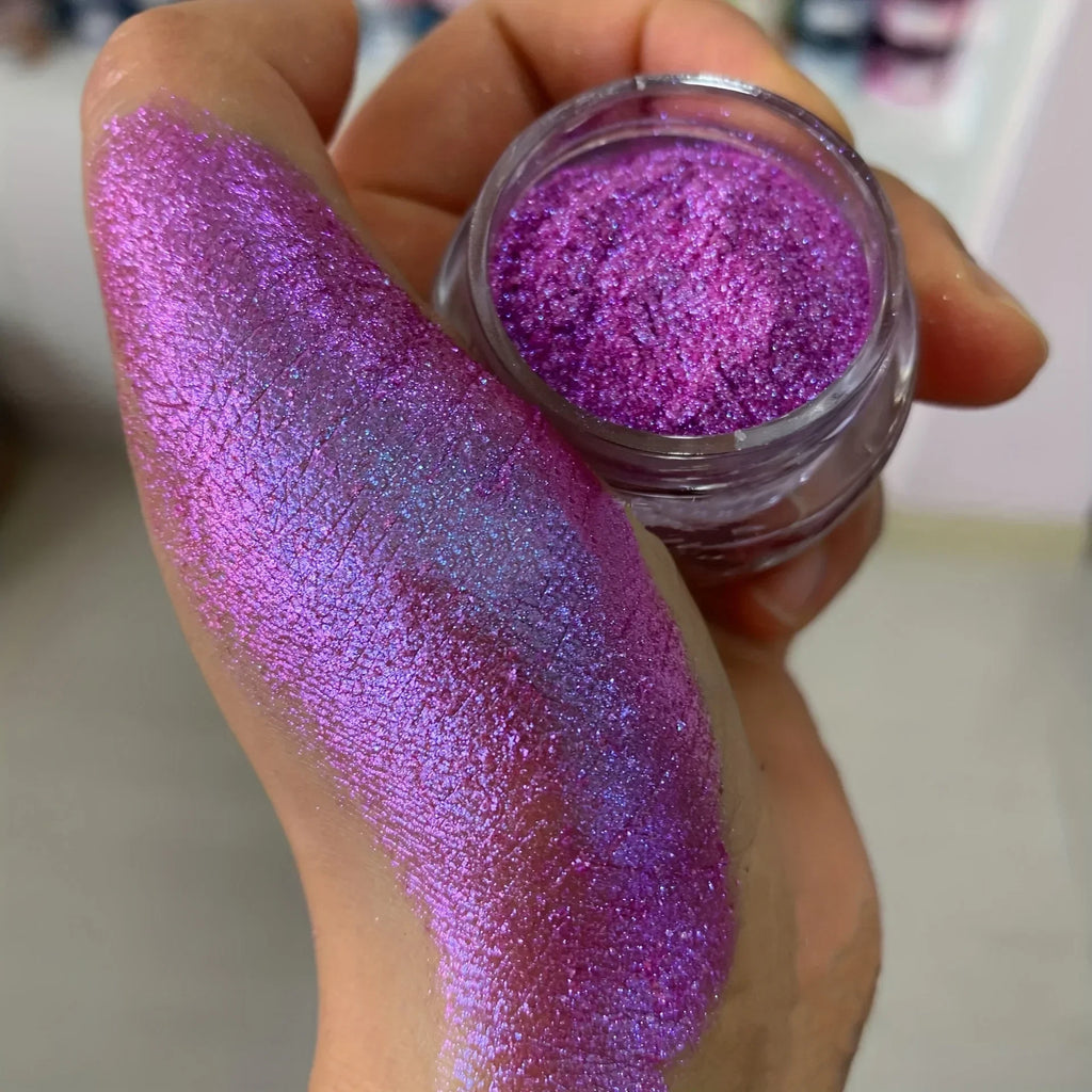 Polvo glitter aurora camaleón vibrante, degradado multicolor, tonos mora, morado, azul y verde, maquillaje corporal deslumbrante