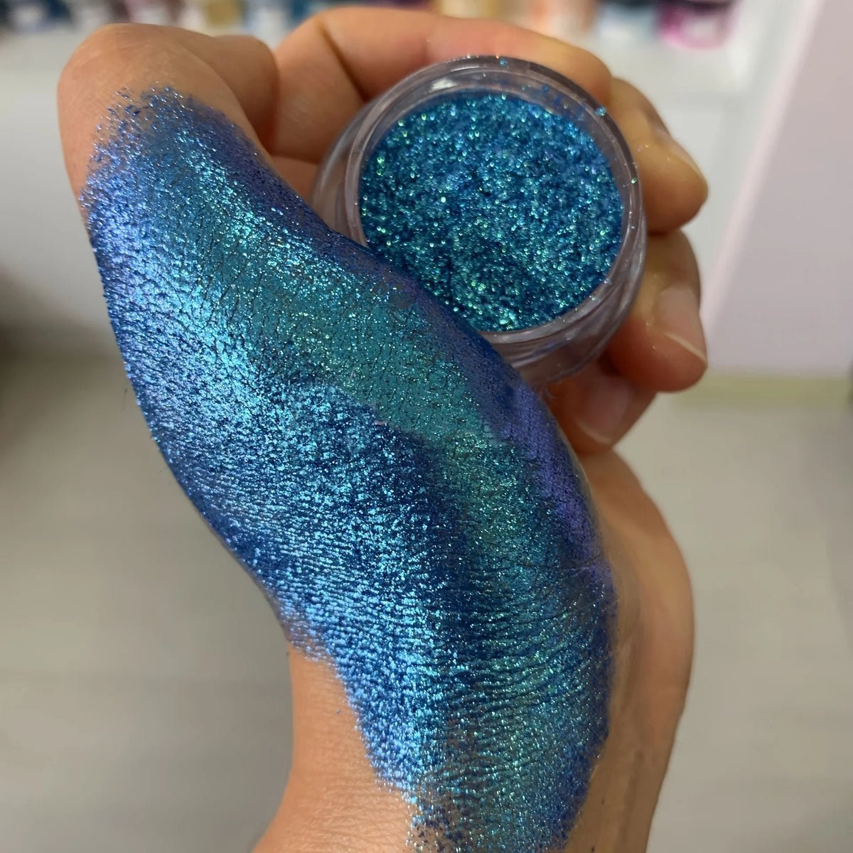 Polvo glitter aurora camaleón vibrante, degradado multicolor, tonos mora, morado, azul y verde, maquillaje corporal deslumbrante